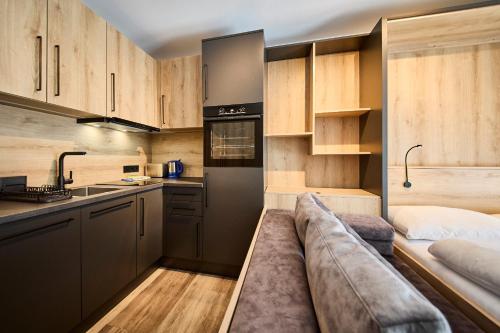 eine Küche mit einem Sofa in der Mitte eines Zimmers in der Unterkunft Appartement Bittner in Saalbach-Hinterglemm