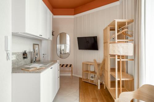 - une cuisine avec des placards blancs et une étagère en bois dans l'établissement Avanti Palazzo, à Cracovie