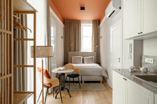 Habitación pequeña con cama, mesa y sillas en Avanti Palazzo en Cracovia