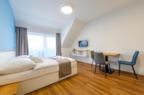a bedroom with a bed and a desk and chairs at Berill Suites in Sárvár