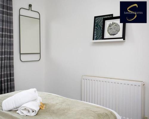 泰恩河畔新堡的住宿－Cosy Business Haven - 3 Bed Newcastle City - FREE PARKING，卧室配有一张壁挂镜子的床