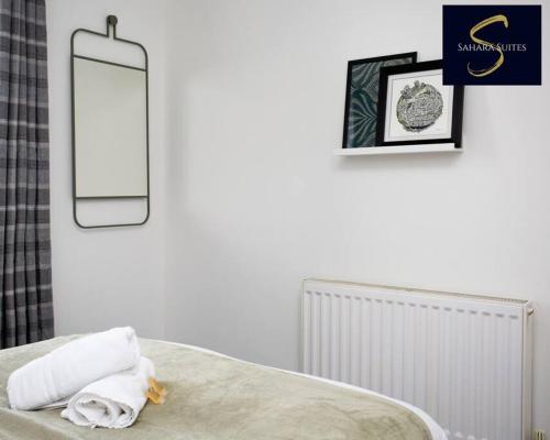 een slaapkamer met een bed met een spiegel aan de muur bij Cosy Business Haven - 3 Bed Newcastle City - FREE PARKING in Newcastle upon Tyne