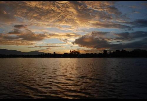 a sunset over a large body of water at H.B.victoria Garden in Srinagar