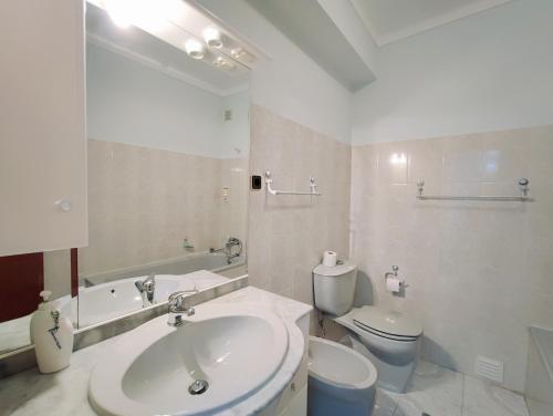 a white bathroom with a sink and a toilet at Apartamento do Castelo in Melgaço