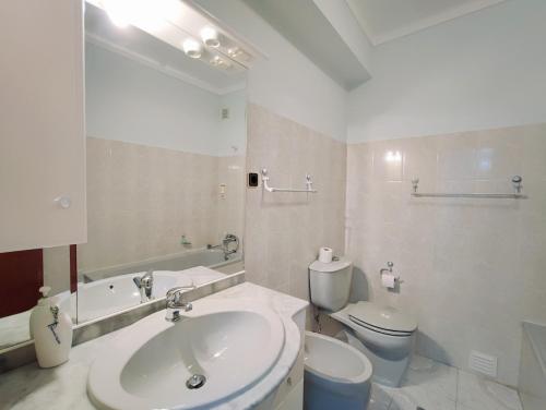 メルガソにあるApartamento do Casteloの洗面台とトイレを備えた白いバスルーム