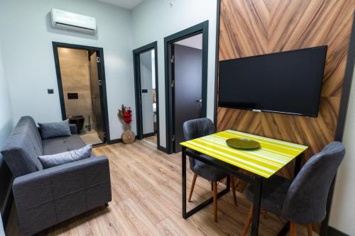 a living room with a table and a tv at Yusufhan Suites in Trabzon