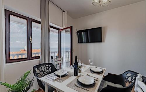 ein Esszimmer mit einem Tisch, Stühlen und einem Fenster in der Unterkunft 2 Bedroom Nice Apartment In Prigradica in Prigradica