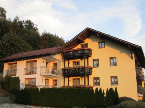 a yellow house with balconies on the side of it at Annie´s Bergchalets - Haus Hochfall in Bodenmais