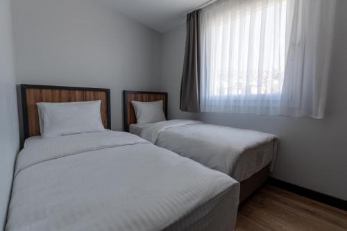 two twin beds in a room with a window at Yusufhan Suites in Trabzon