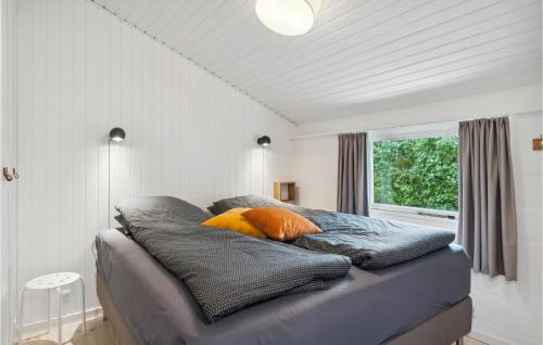 a bedroom with a bed with pillows and a window at Beautiful Home In Frederikshavn With Kitchen in Frederikshavn
