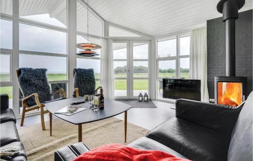 a living room with a couch and a table and a fireplace at Three-Bedroom Holiday Home In Nordborg in Nordborg
