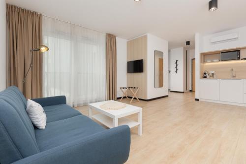 ein Wohnzimmer mit einem blauen Sofa und einem Tisch in der Unterkunft Comfy Studio Targowa next to PGE Narodowy by Renters in Warschau