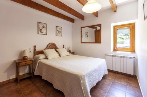 una camera bianca con un letto e una finestra di Cal Colom a Puigreig