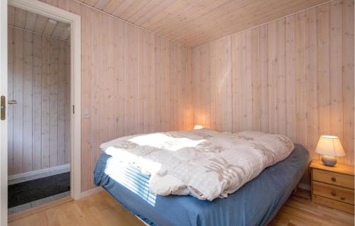 a bedroom with a bed in a room with wooden walls at Beautiful Home In Hadsund With 3 Bedrooms And Wifi in Helberskov