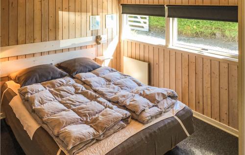 Cette chambre en bois comprend un grand lit et une fenêtre. dans l'établissement Beautiful Home In Bogense With Kitchen, à Bogense
