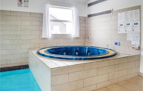 ロッケンにあるAwesome Home In Lkken With 9 Bedrooms, Internet And Indoor Swimming Poolのスイミングプール付きのバスルームにはジャクジータブが備わります。