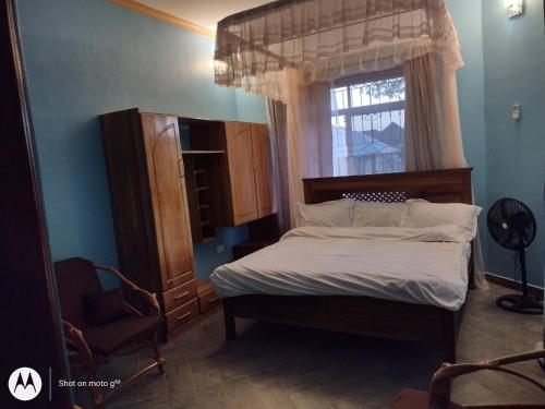 1 dormitorio con cama y ventana en Luxury Villa Garden, en Dar es Salaam