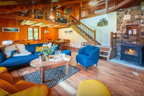 a living room with blue couches and a fireplace at La Ferme du Cortet - OVO Network in Thônes