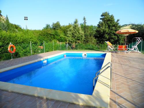 a swimming pool with blue water in a backyard at Brigida in Verucchio