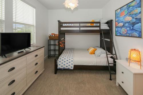 Habitación pequeña con litera y TV en Sea Glass Villa, en Oceanside
