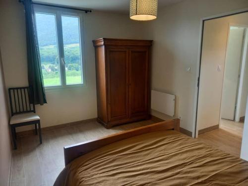 um quarto com uma cama, um armário e uma janela em Gîte - La Maldina em Oriol-en-Royans