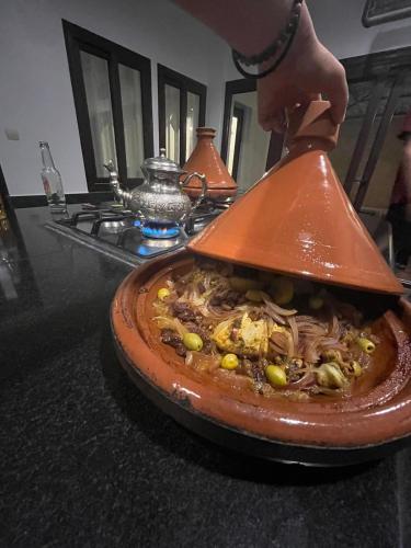 a person is preparing a dish of food on a counter at Riad Searenity in Tamraght Ouzdar