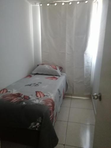 a small room with a bed and a window at Jantcar Suites in Santiago