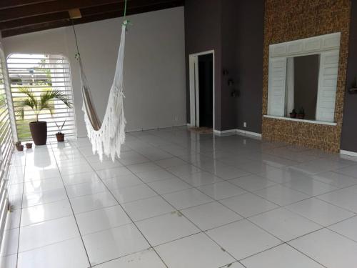 a white tile floor in a room with a hammock at Pousada Tia Míria 