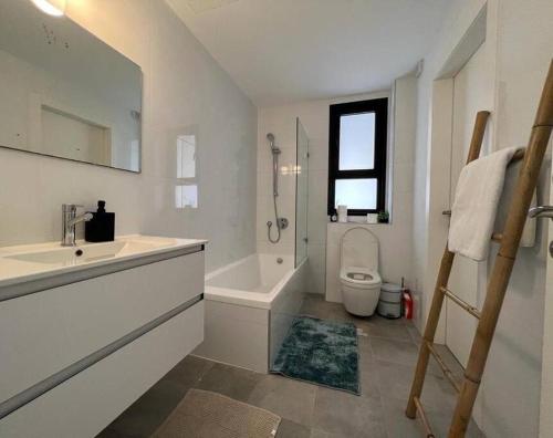 a white bathroom with a sink and a toilet at Menahem Arber Pool 5 Bedroom in Tel Aviv