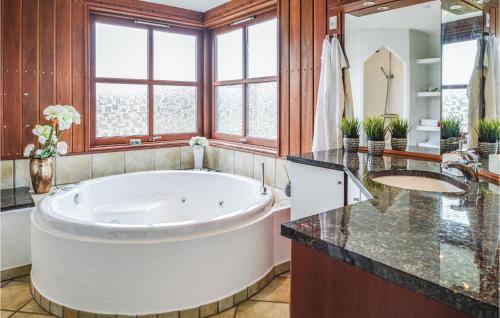 Saltum的住宿－Beautiful Home In Saltum With House A Panoramic View，大型浴室设有大浴缸和两个水槽