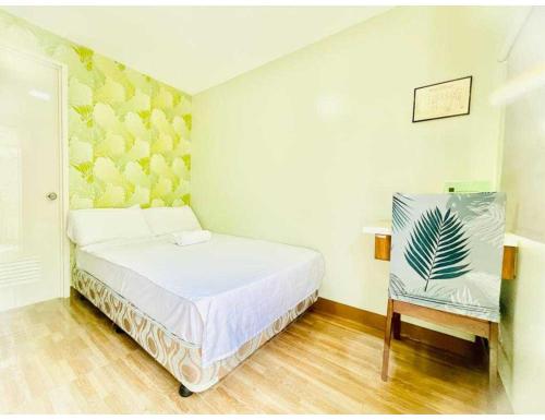 a small bedroom with a bed and a chair at OYO 1008 Armond Bed And Breakfast in Mactan