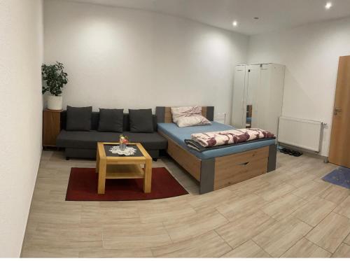 ein Wohnzimmer mit einem Sofa und einem Tisch in der Unterkunft Studio Apartment Zentrum Rüsselsheim in Falkenberg