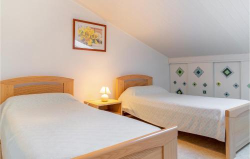 ラ・フォット・シュル・メールにある3 Bedroom Lovely Home In La Faute Sur Merのランプ2つが備わる客室で、ツインベッド2台が付いています。