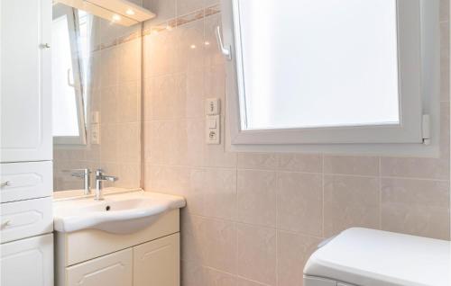 a bathroom with a sink and a toilet and a window at Nice Home In La Faute Sur Mer With 3 Bedrooms And Wifi in La Faute-sur-Mer