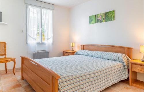 a bedroom with a bed and a chair and a window at Nice Home In La Faute Sur Mer With 3 Bedrooms And Wifi in La Faute-sur-Mer