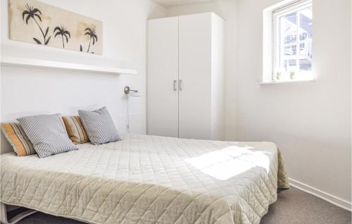 a bedroom with a bed in a white room at Lovely Apartment In Bogense With Sauna in Bogense