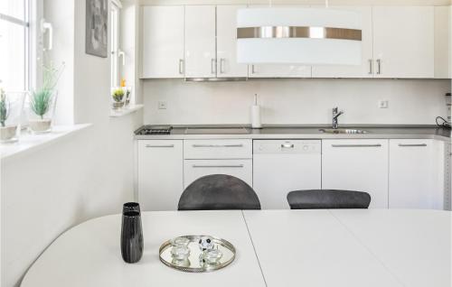 a white kitchen with white cabinets and a sink at Lovely Apartment In Bogense With Sauna in Bogense