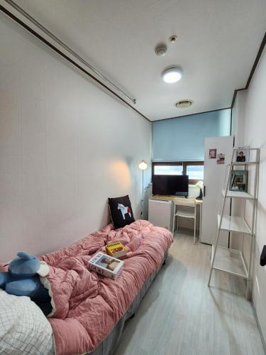 a bedroom with a bed with a pink blanket at Coem Livingtel in Goyang