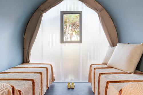 a room with two beds and a window at Gitavillage Il Gabbiano in Albinia