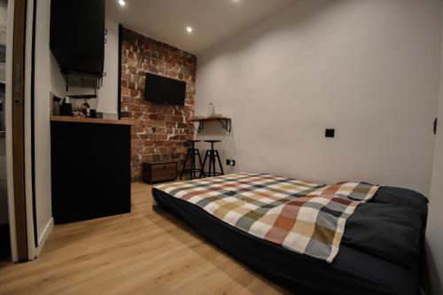 une chambre avec un lit et un mur de briques dans l'établissement T1 PRESTIGE PARIS MONTMARTRE, à Paris
