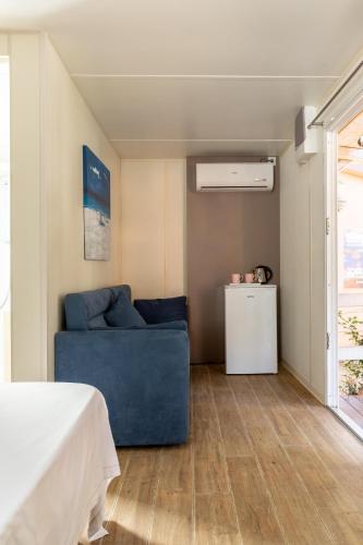 a living room with a blue couch and a window at Gitavillage Il Gabbiano in Albinia