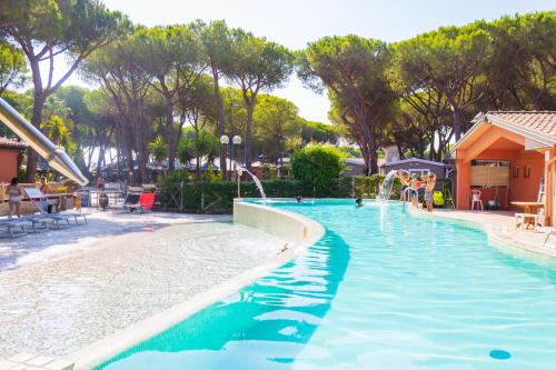una piscina en un complejo con gente jugando en él en Gitavillage Il Gabbiano, en Albinia
