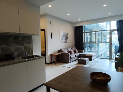 a kitchen and living room with a couch and a table at Skynest Residences by Lisa's Paradise A in Nairobi
