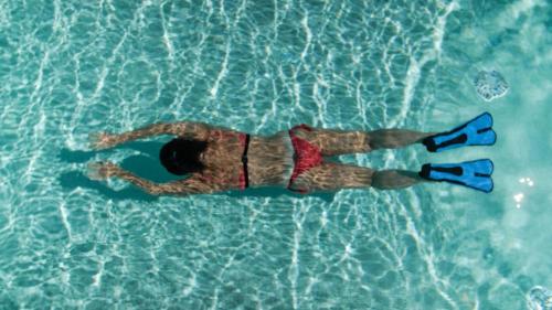 a man laying in the water in a pool at Gitavillage Il Gabbiano in Albinia