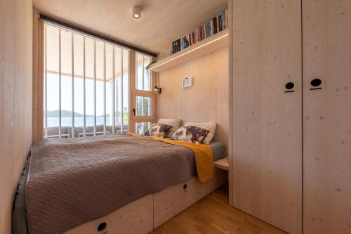 een slaapkamer met een bed en een groot raam bij BUQEZ VILLAS - VILLA 78 in Drage