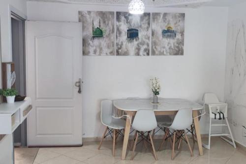 ein weißes Esszimmer mit einem Tisch und Stühlen in der Unterkunft la maison du repos in Oulad Kerroum