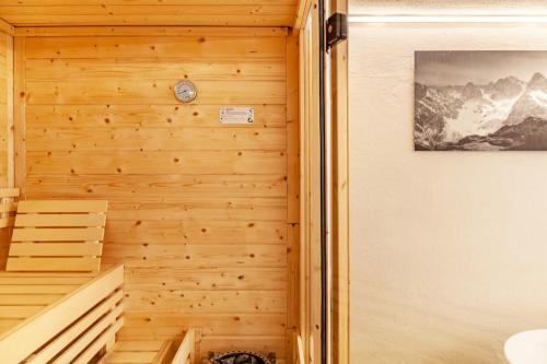 a sauna with wooden walls and a clock on the wall at Villa Maria Tirol in Anras
