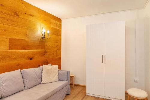 a living room with a couch and a wooden wall at Villa Maria Tirol in Anras