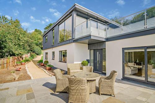 a patio with chairs and a table in front of a house at Conifers in Lyme Regis