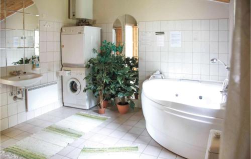 y baño con bañera y lavadora. en Beautiful Home In rsted With Kitchen en Kare